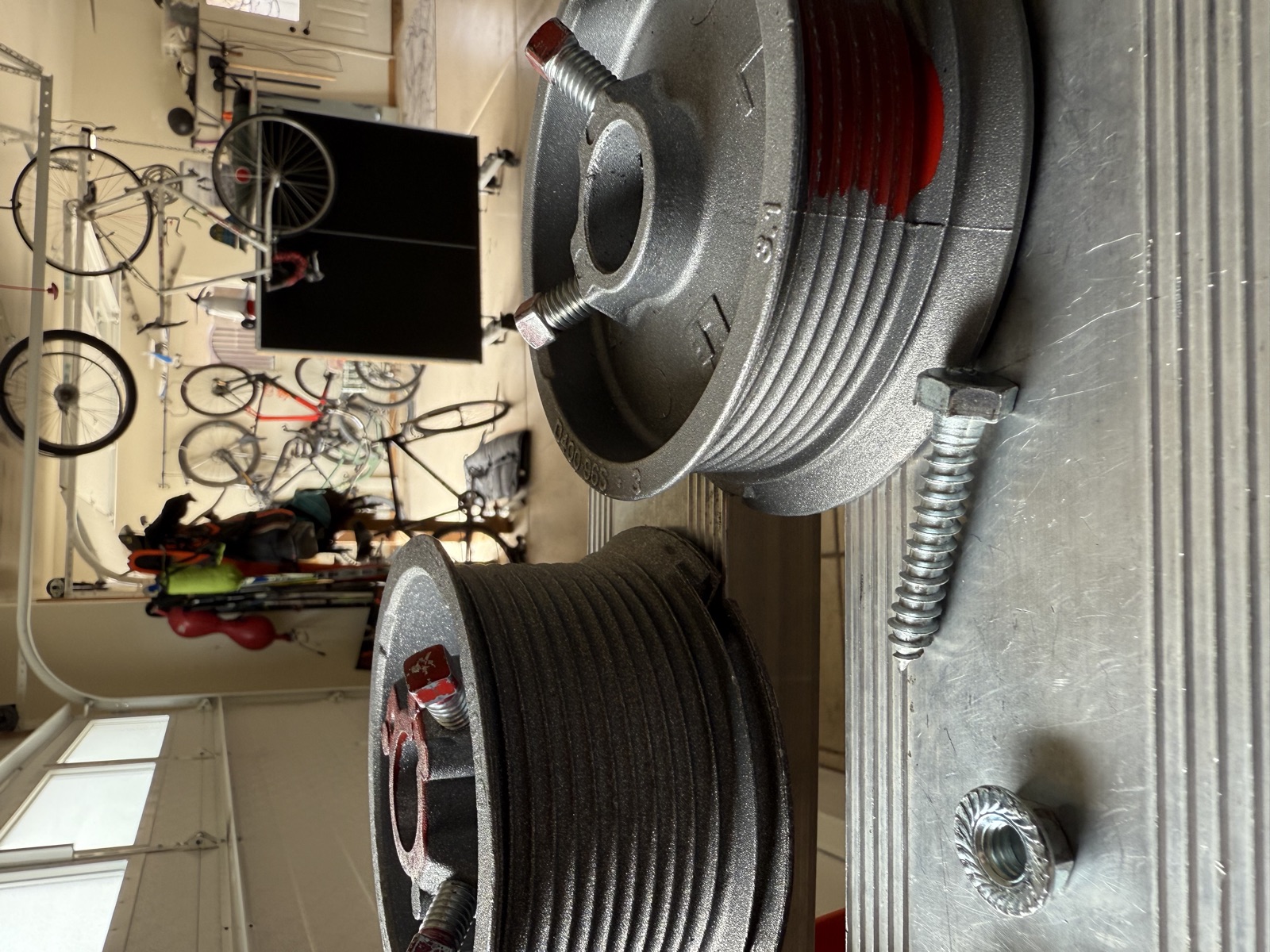 Garage door cable drums and hardware laid out during a repair