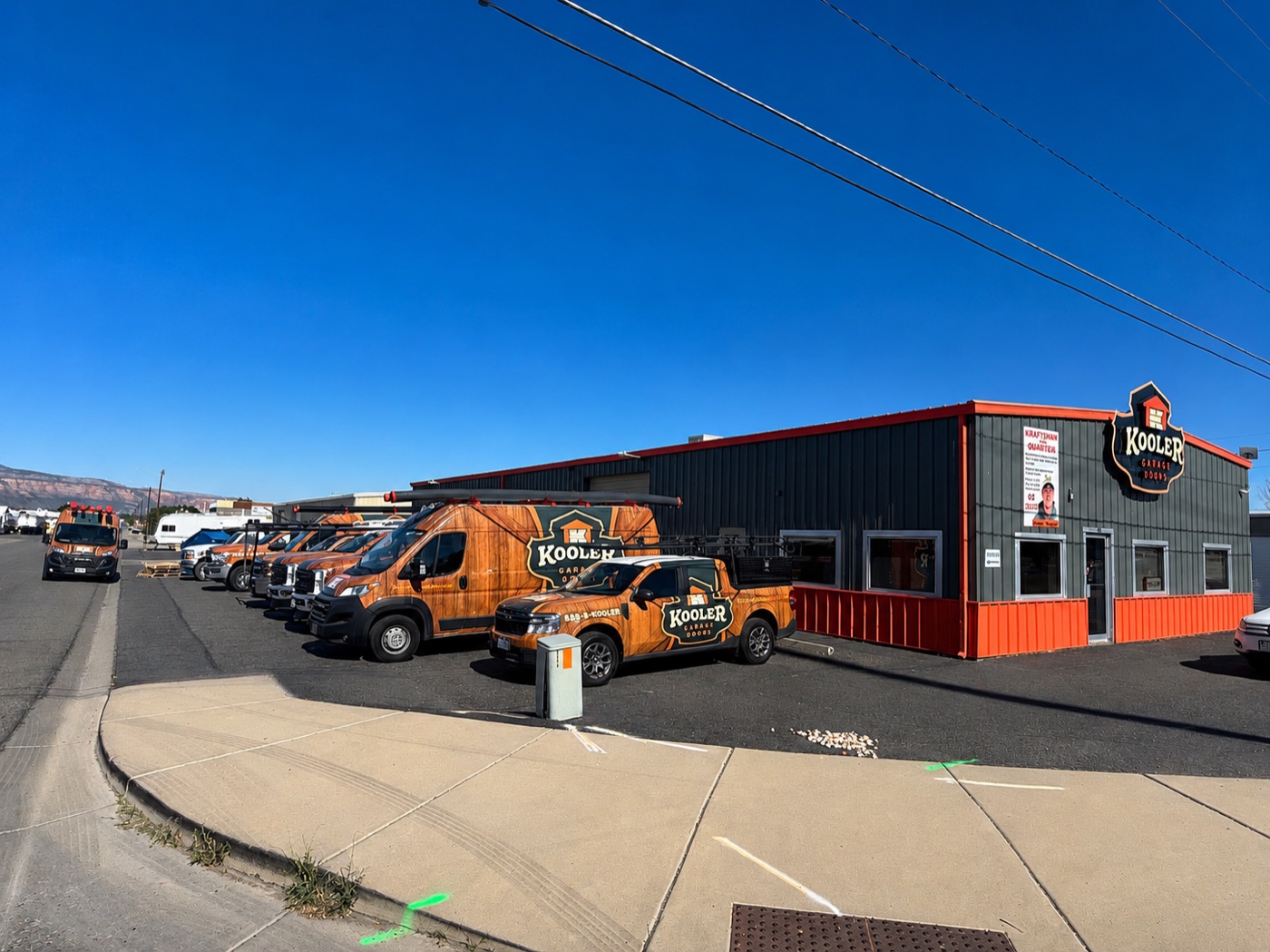 The Kooler Garage Doors shop in Grand Junction with the service fleet parked alongside it.