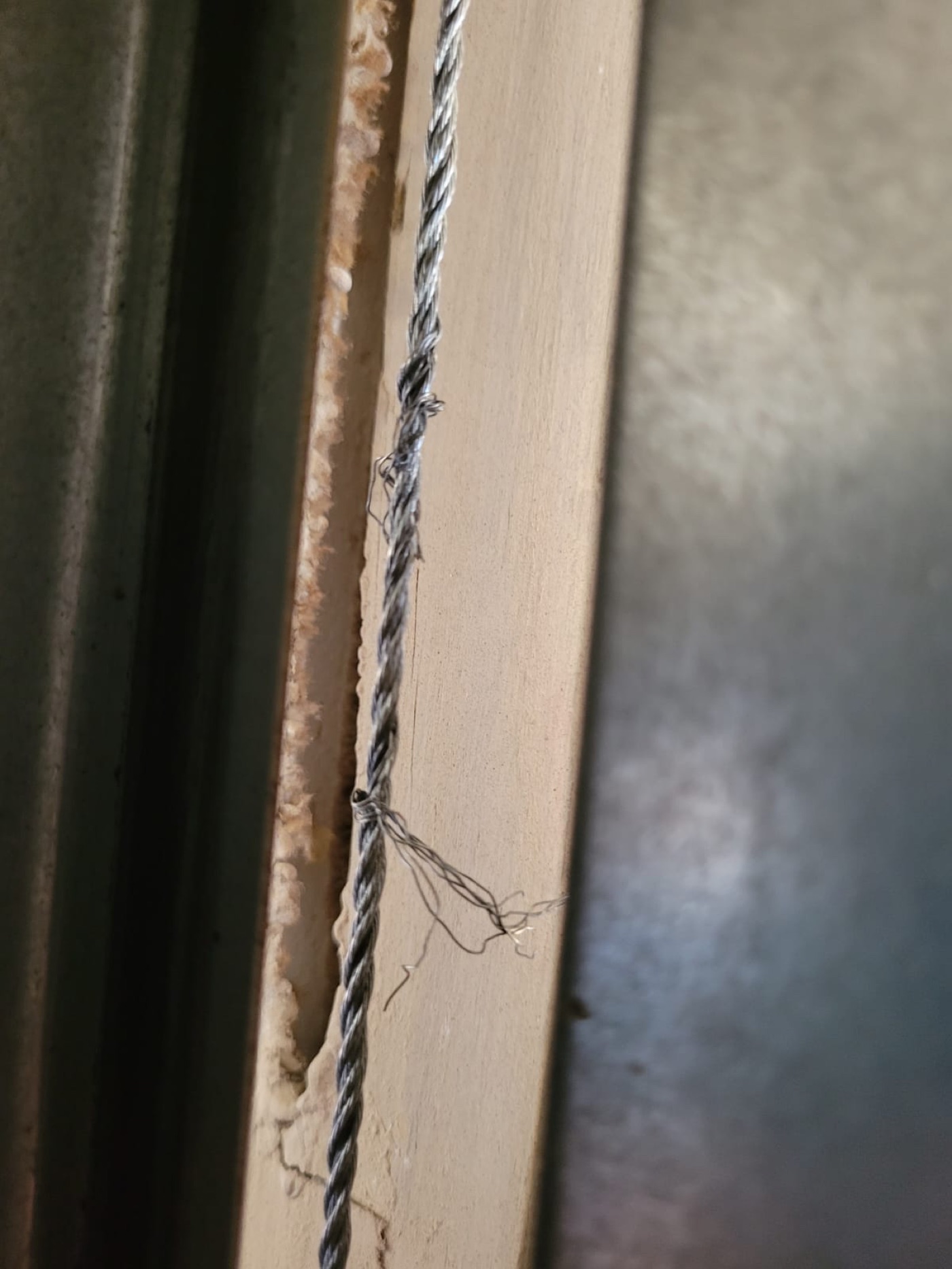 A frayed garage door lift cable — the exact failure Kooler replaces in pairs before the door drops