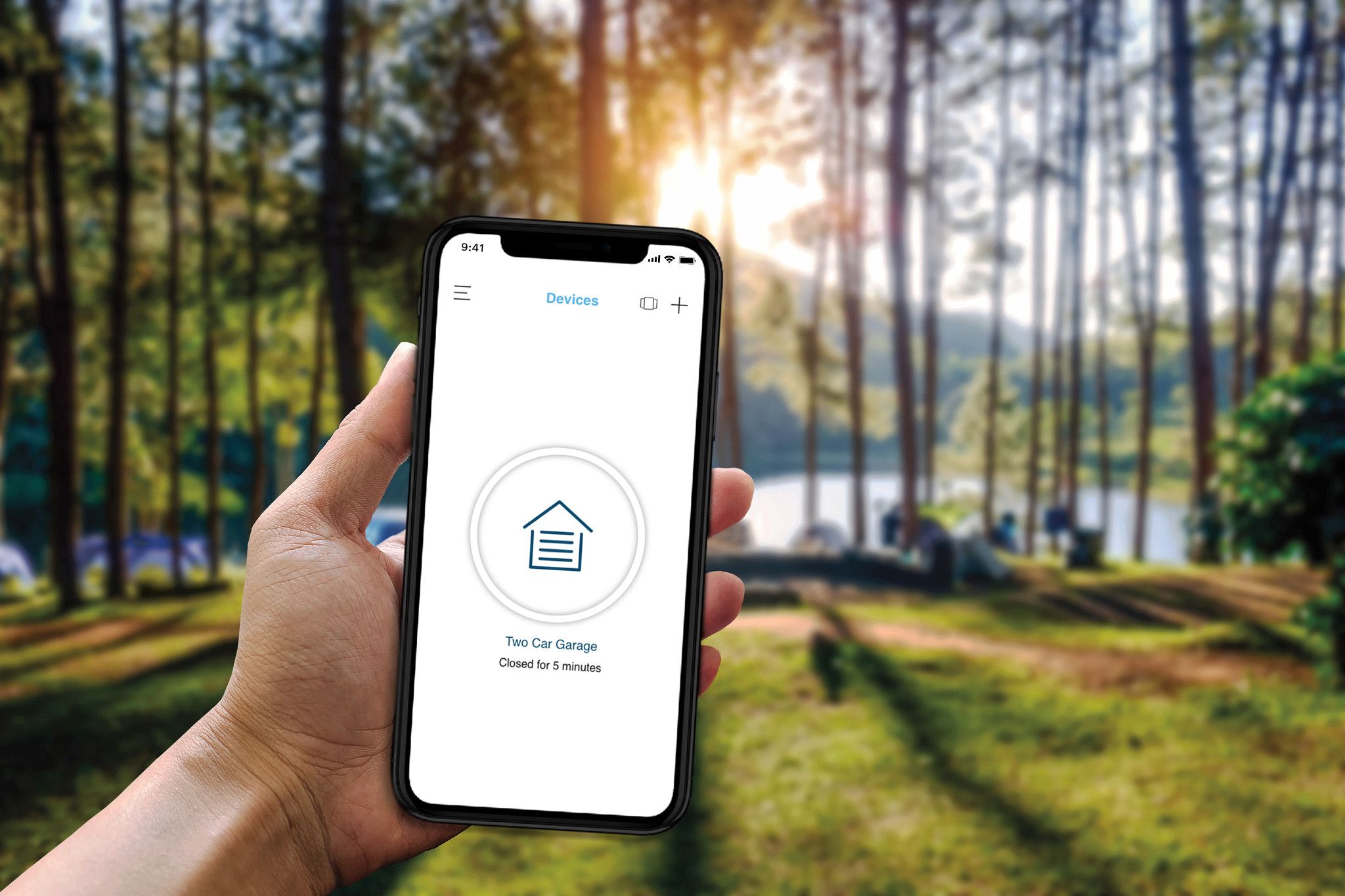 The myQ app open on a phone, showing the garage door closed, with a Western landscape in the background